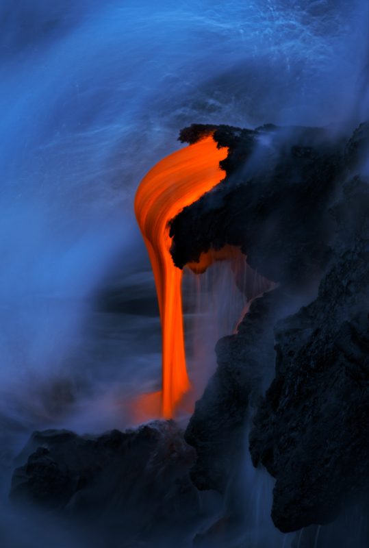 Glowing lava drips into the sea